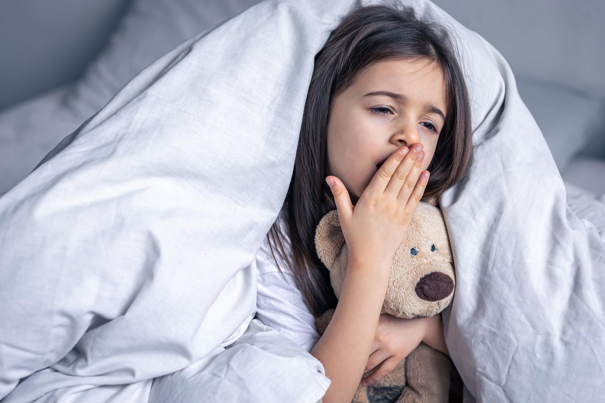 sleepy little girl with her favorite teddy bear bed morning